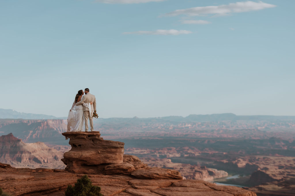 couple stands on overlook at Dead Horse Point State Park Moab elopement