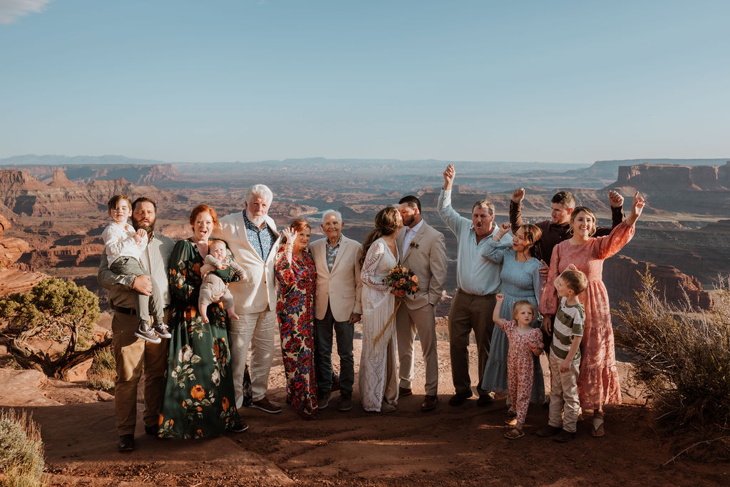 couple cheers with family at Moab elopement
