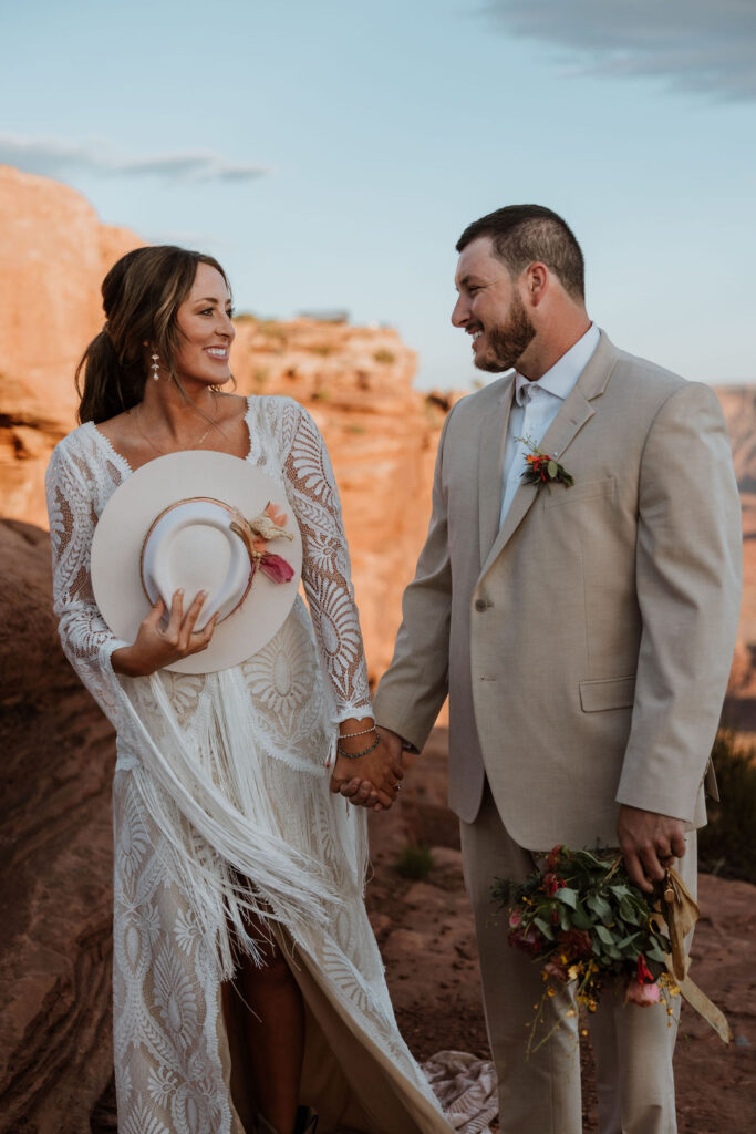 bride holds hat at wedding first look