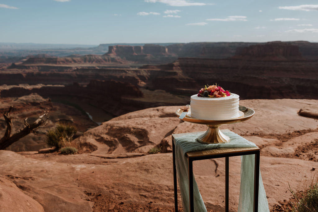 white wedding cake on gold platter at Dead Horse Point State Park Moab elopement