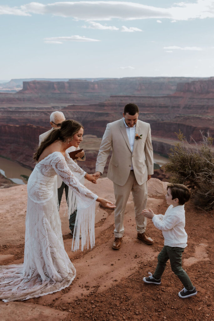 ring bearer hands over ring at Dead Horse Point State Park Moab elopement
