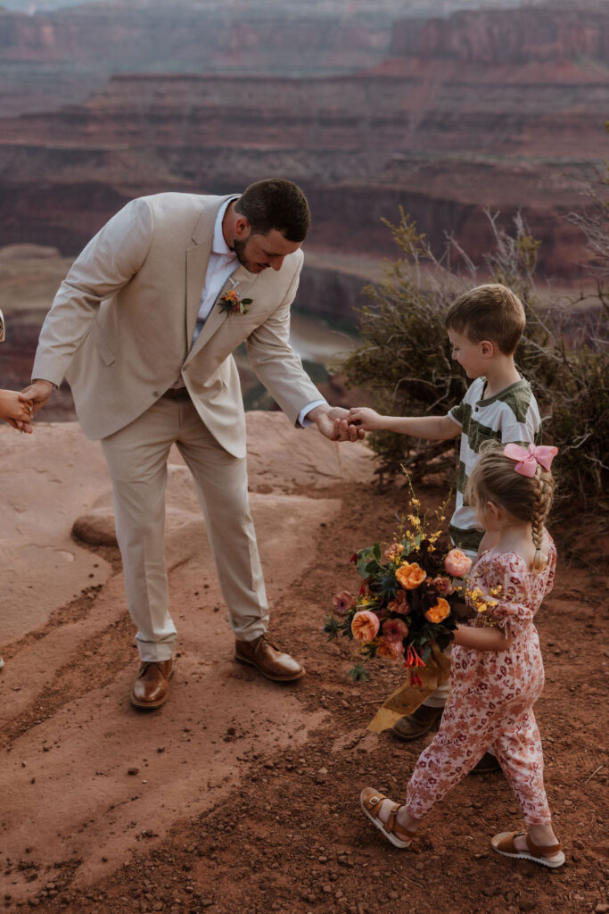 ring bearer hands over ring at Dead Horse Point State Park Moab elopement
