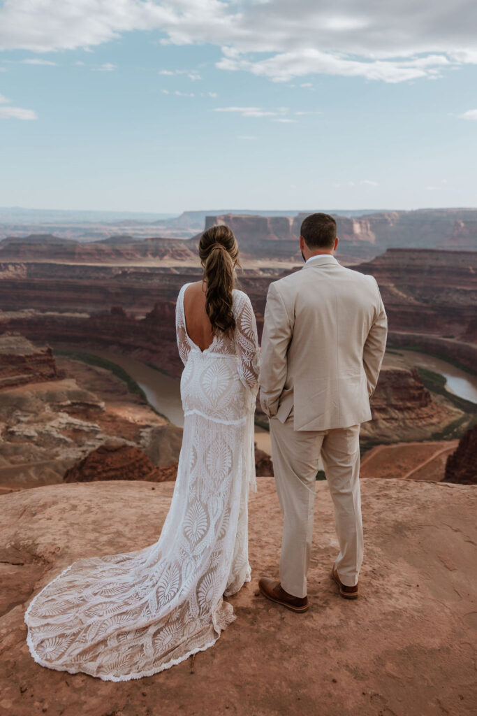 couple stands on overlook at Dead Horse Point State Park Moab elopement