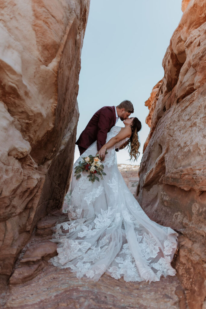 couple stands between rocks at Moab elopement