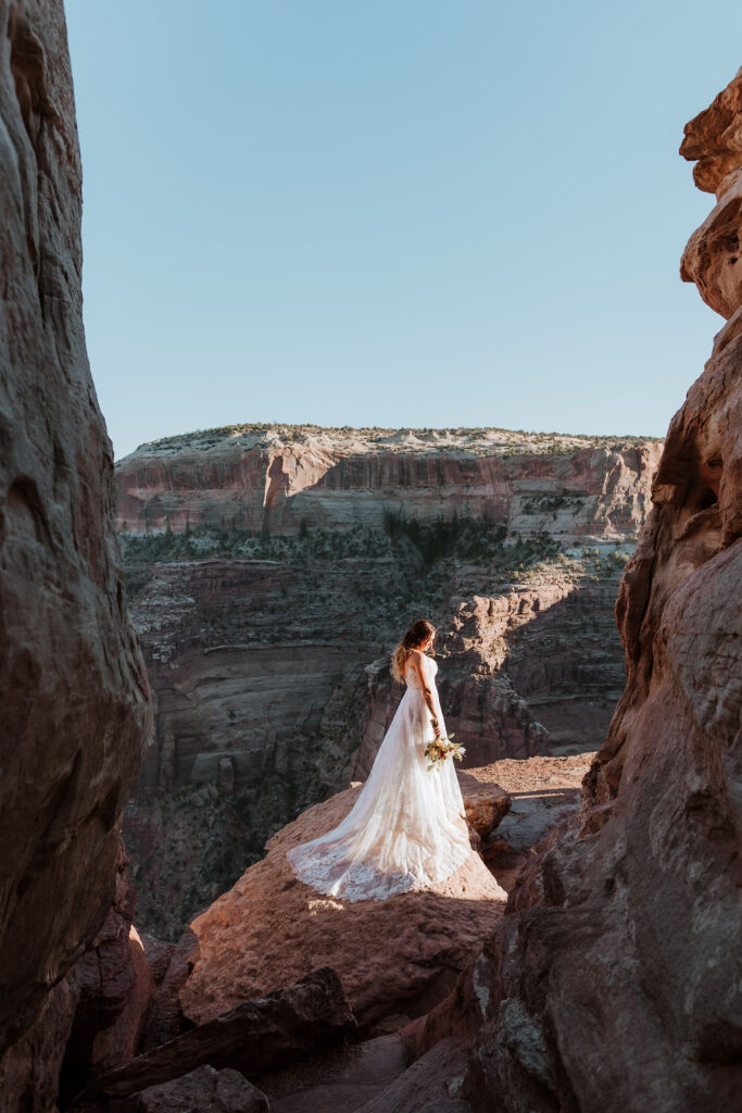 bride stands on overlook at Canyonlands National Park elopement