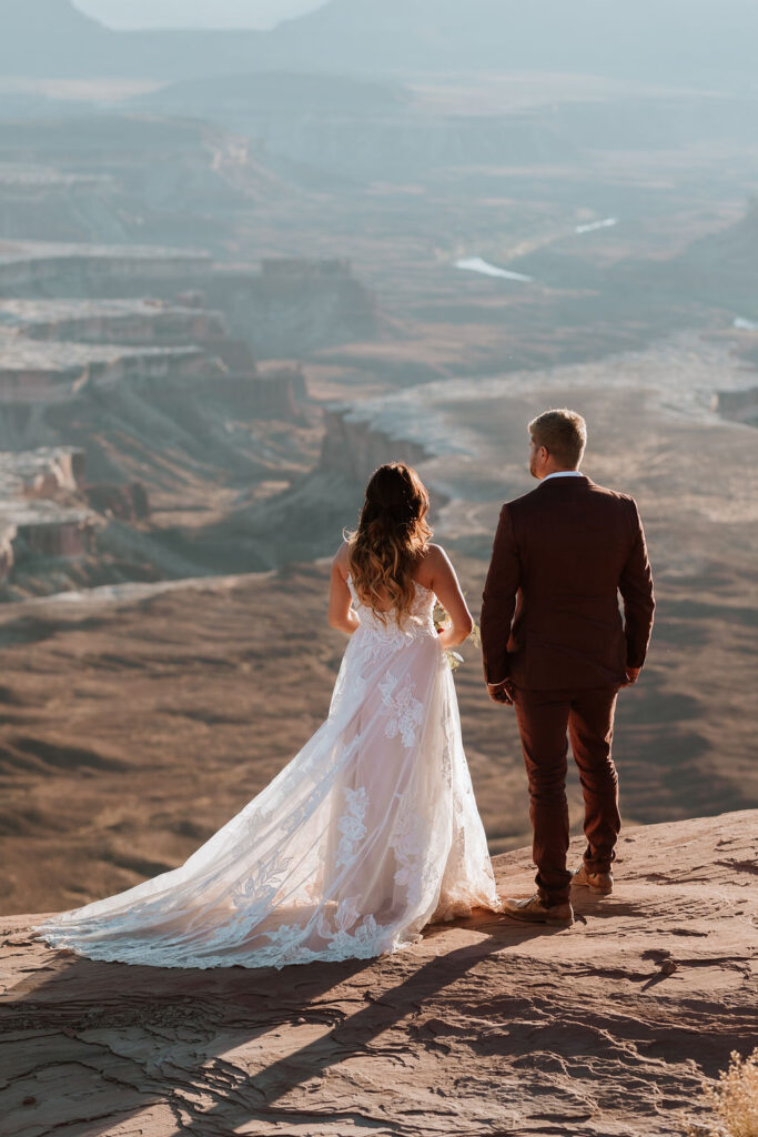 couple stands on rocks at Moab elopement