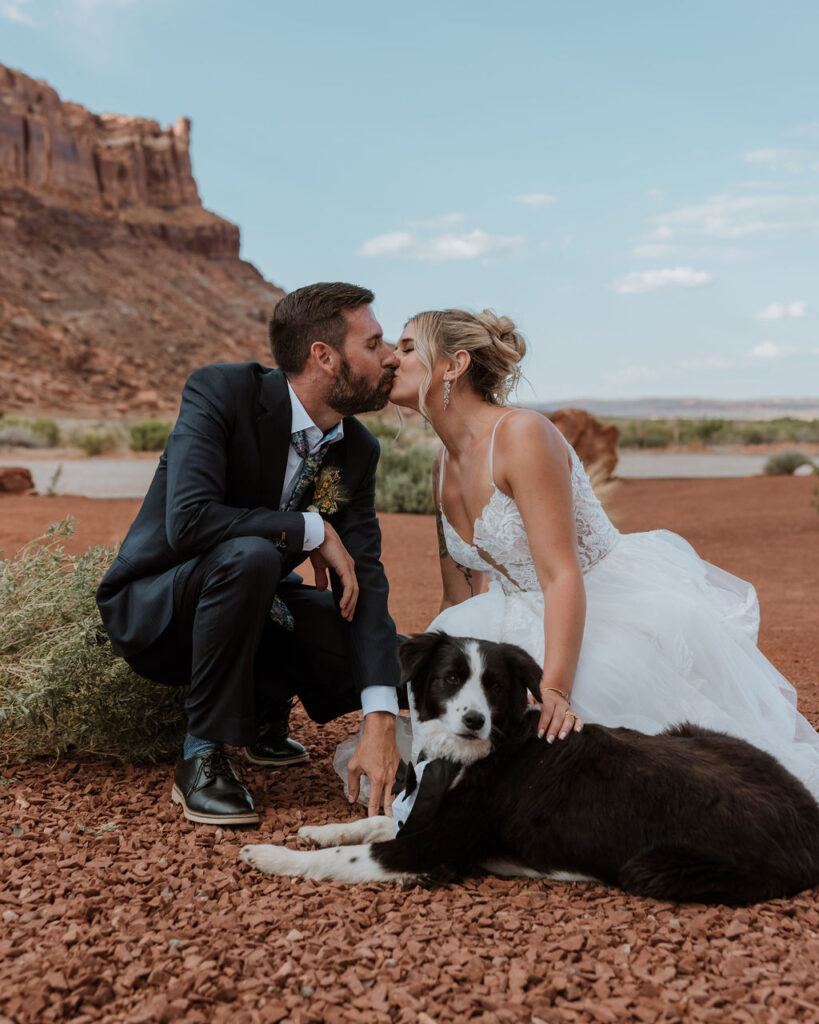 couple kisses with dog at The Red Earth Venue wedding