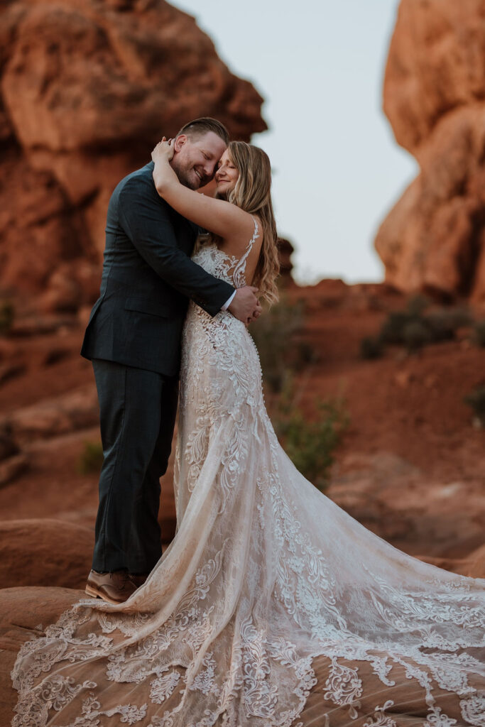 couple embraces at Arches National Park elopement