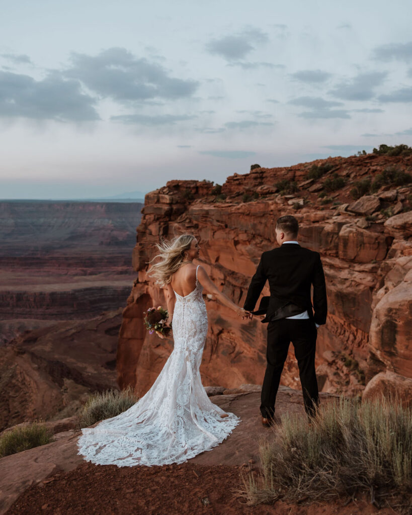 couple holds hands at Moab sunset elopement