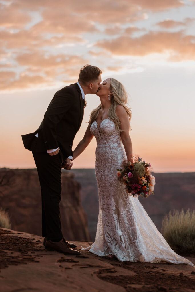 couple kisses at Moab sunset elopement