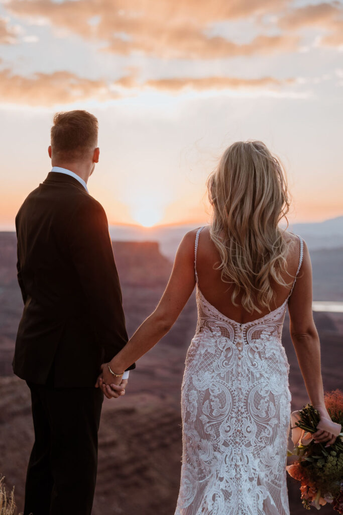 couple holds hands at Moab sunset elopement