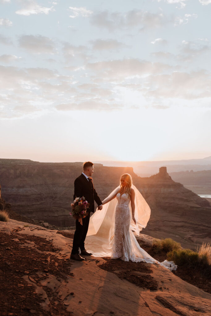 couple holds hands at Moab sunset elopement