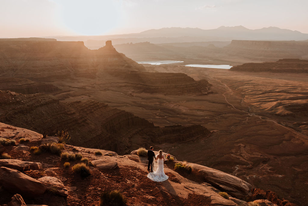 couple holds hands at Moab sunset overlook