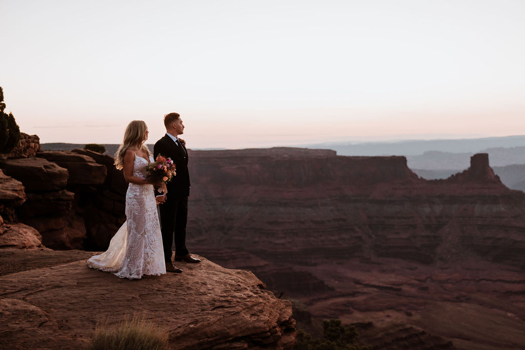 couple holds hands at Moab sunset overlook