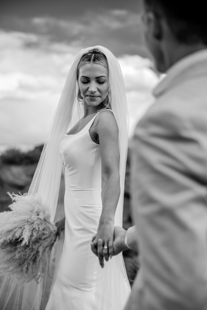 couple walks holding hands at Moab elopement 