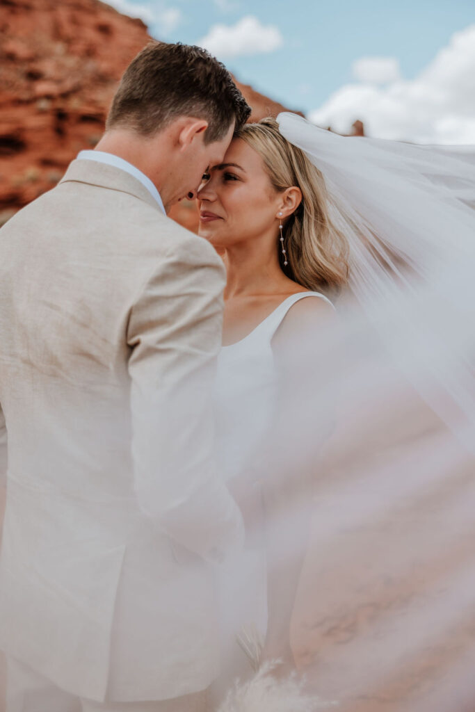 couple embraces at Moab elopement under veil