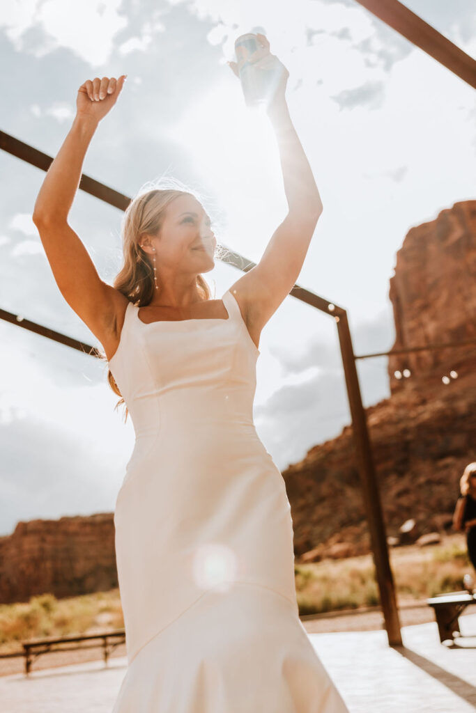 bride dances with drink at Moab wedding 