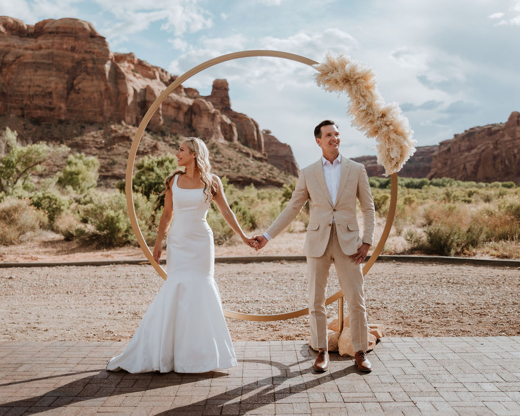 couple holds hands in front of wedding decor at Red Earth Venue wedding