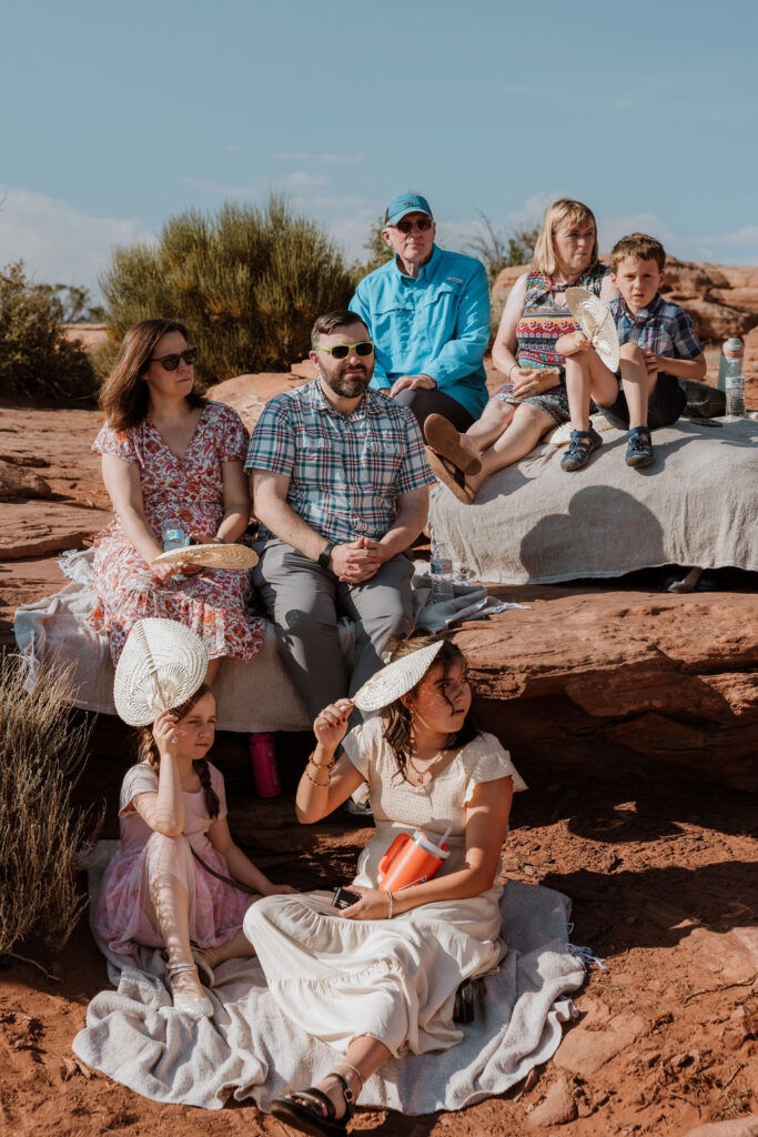 guests watch wedding ceremony on Moab rocks 