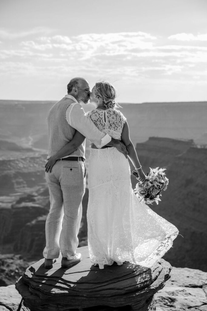 couple kisses at Moab overlook