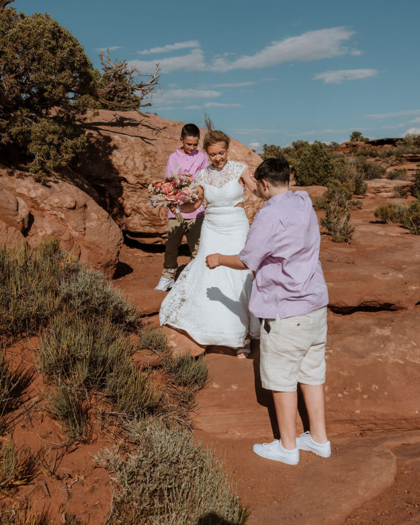 bride walks down rocks at Moab elopement 