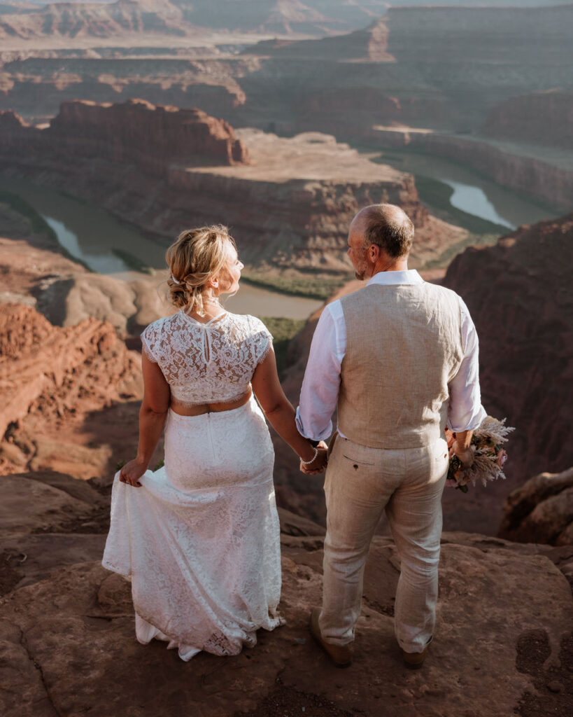 couple stands at overlook at Moab wedding