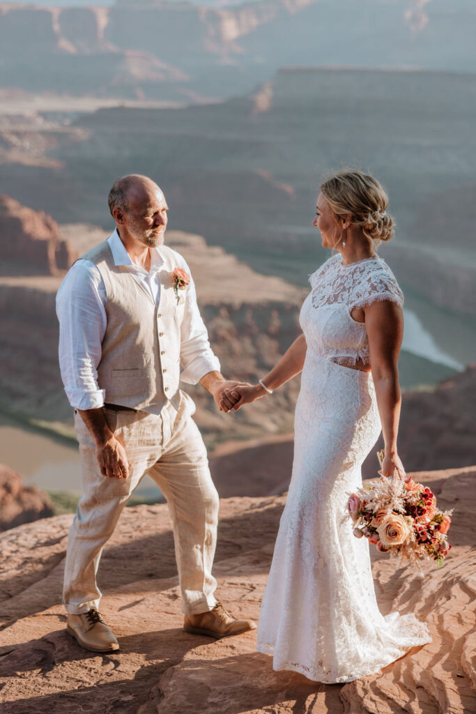 couple walks along Utah landscape at Moab wedding