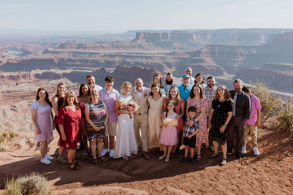 couple poses with wedding guests at Moab overlook wedding