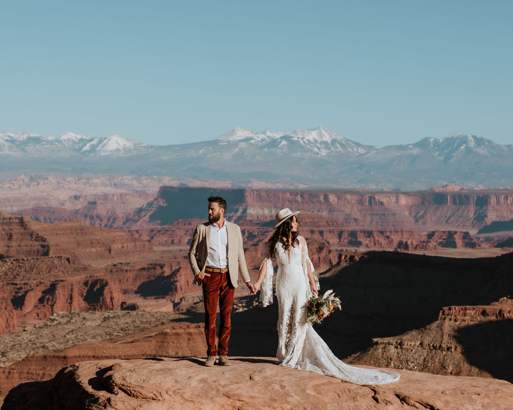 couple holds hands at Canyonlands overlook elopement