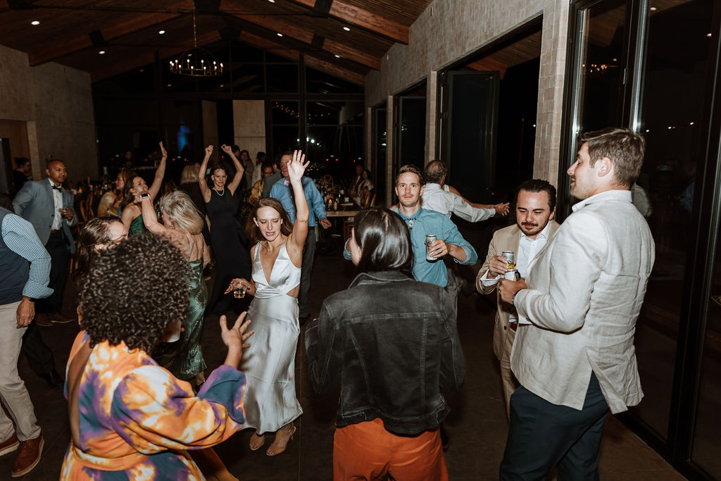 couple dances with wedding guest during wedding reception