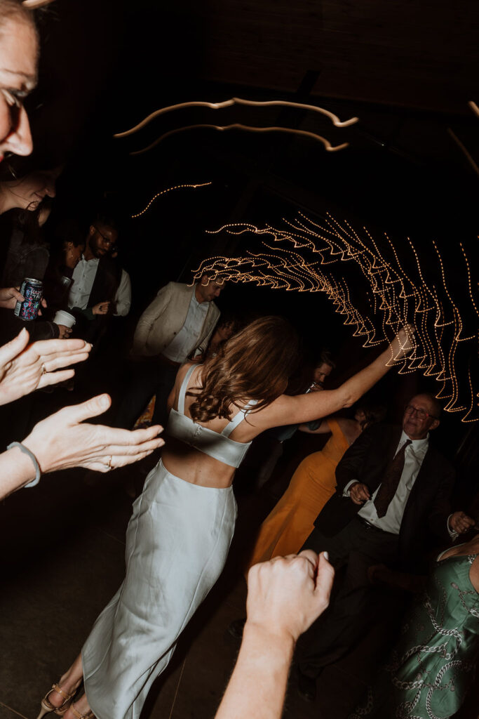 couple dances with wedding guest during wedding reception