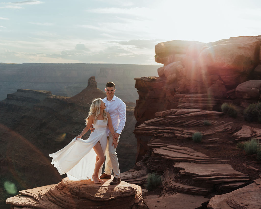 couple embraces on overlook at Dead Horse State Park sunset elopement