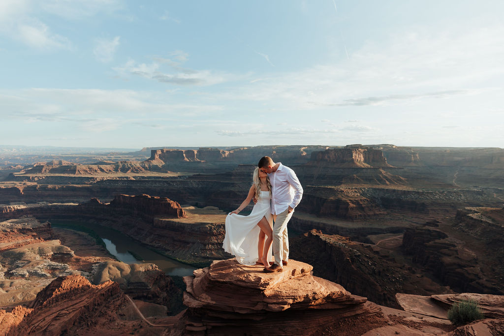 couple kisses on ledge at Dead Horse State Park sunset elopement