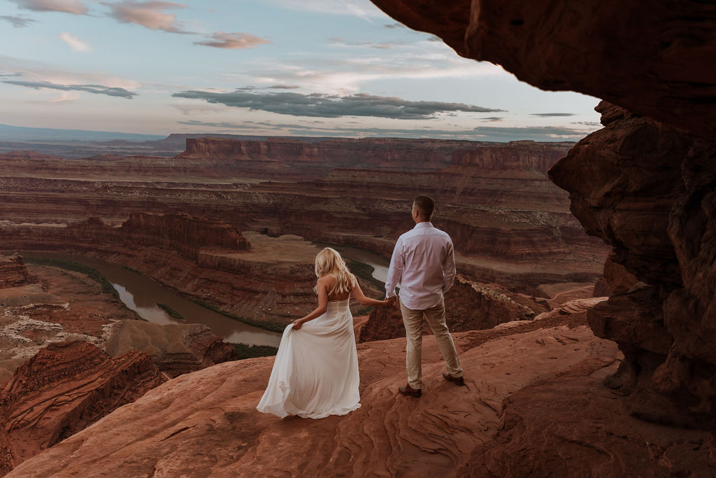 couple looks over overlook at Dead Horse State Park elopement