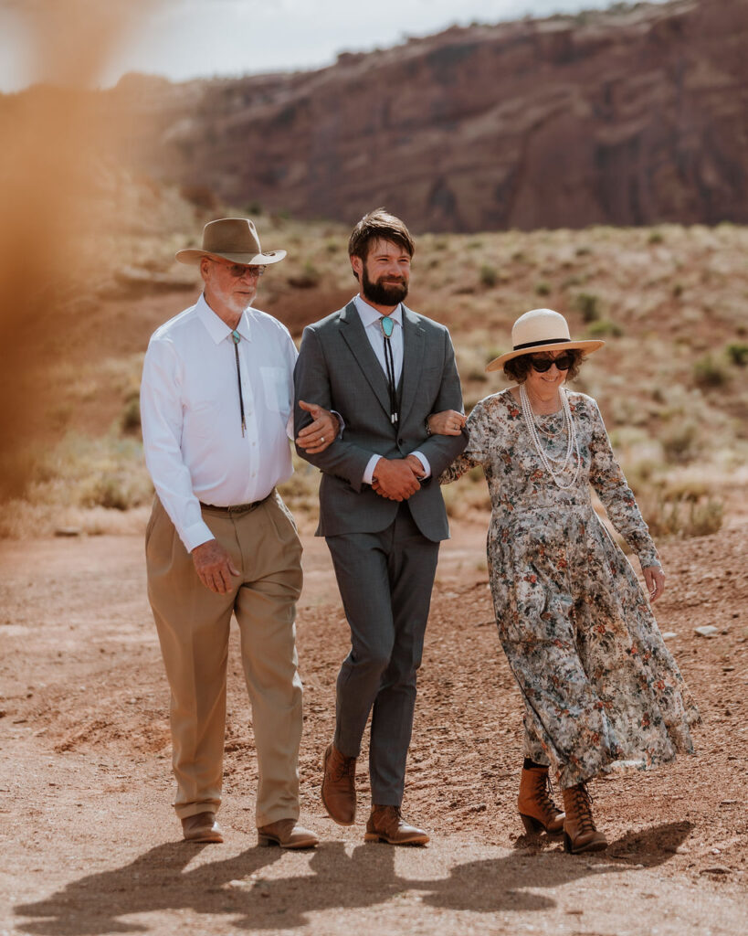 parents walk groom down aisle at Red Earth Venue wedding