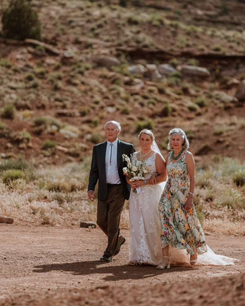 parents walk bride down aisle at Red Earth Venue wedding