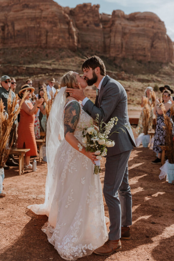 couple kisses during wedding exit at Red Earth Venue wedding