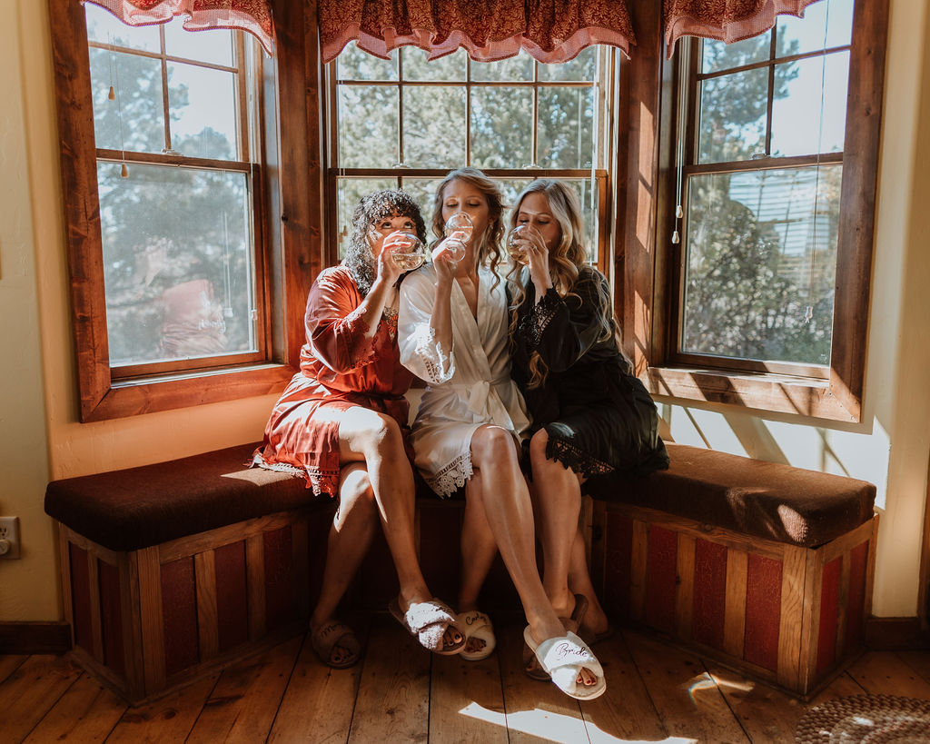 bride drinks with bridesmaids in silk robes