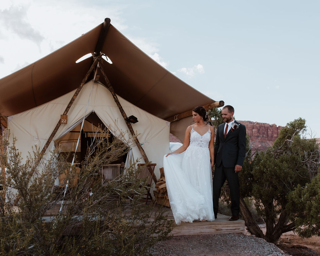 wedding couple poses at Under Canvas Moab tent