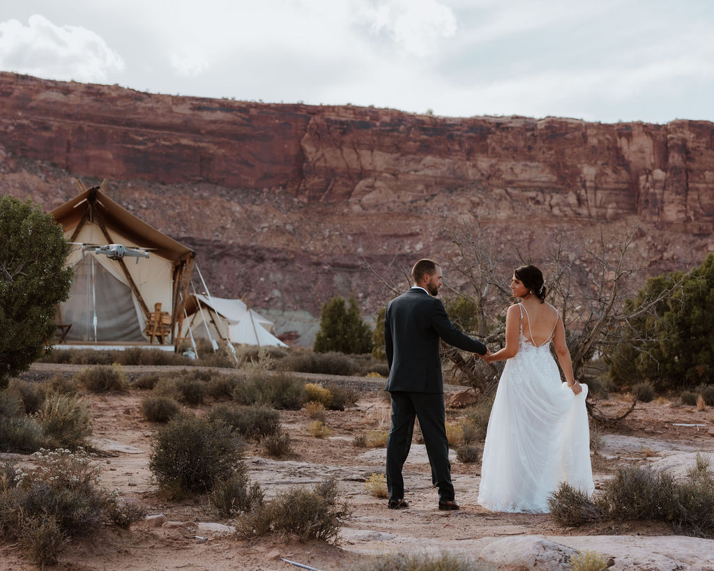 wedding couple poses at Under Canvas Moab tent