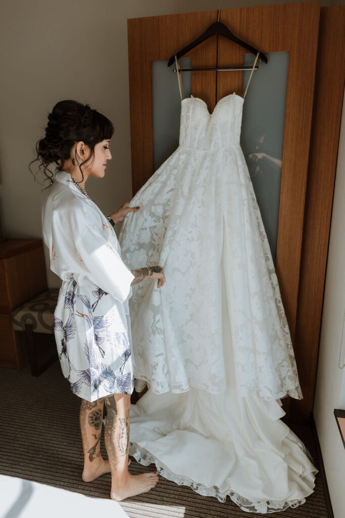 bride holds wedding dress on wedding day