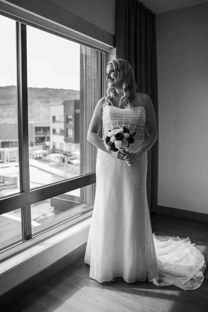 bride poses by window at top where to stay in Moab location