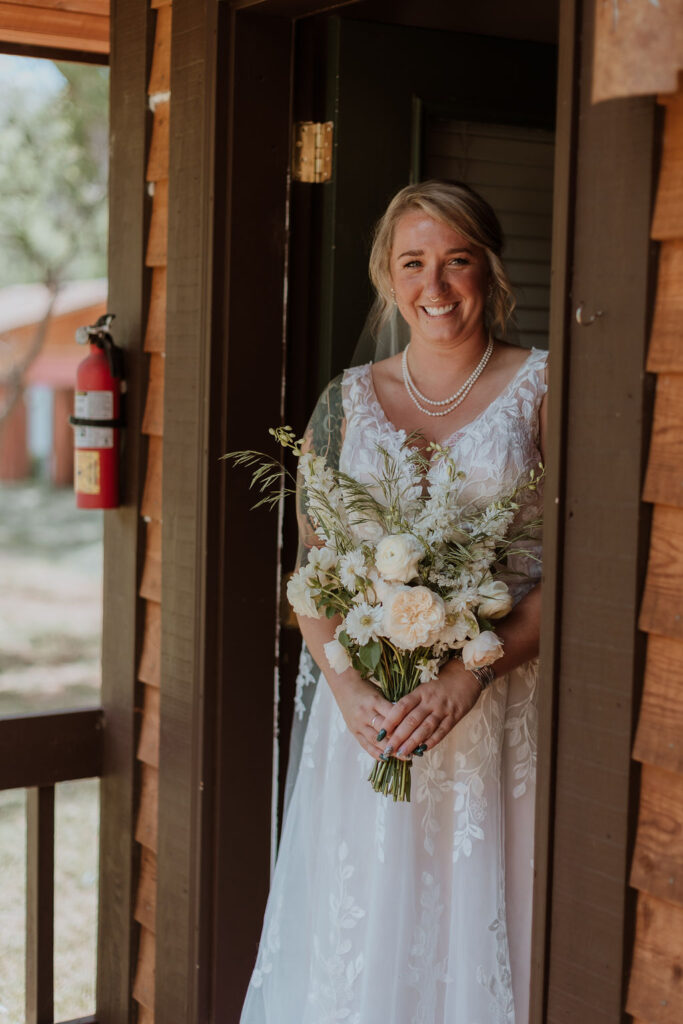 bride poses in doorway holding wedding bouquet 