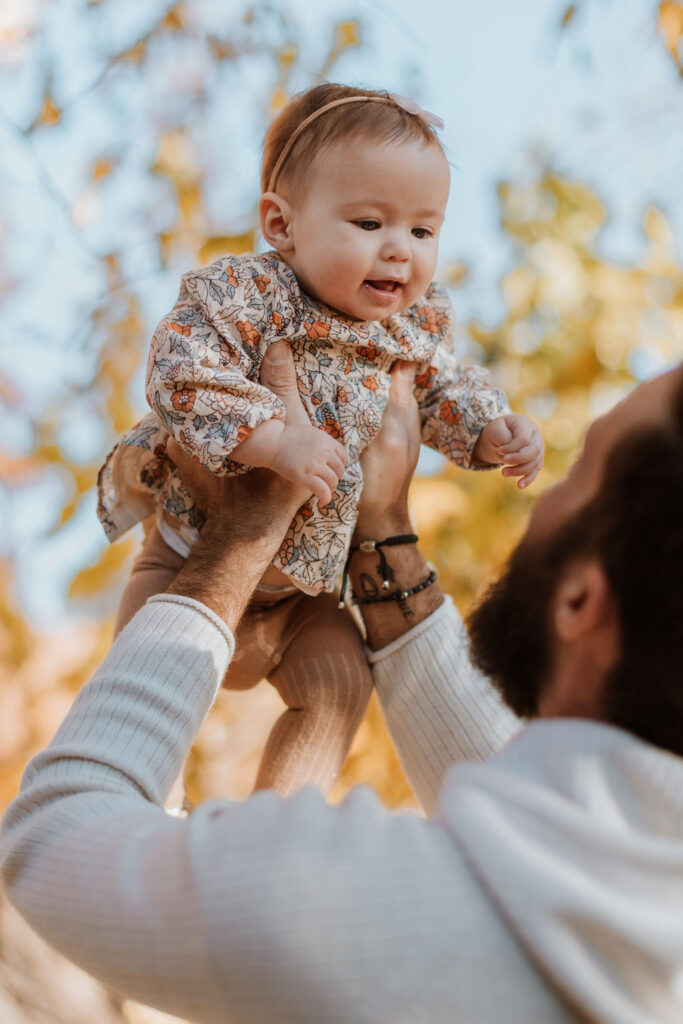 dad holds up baby at newborn session