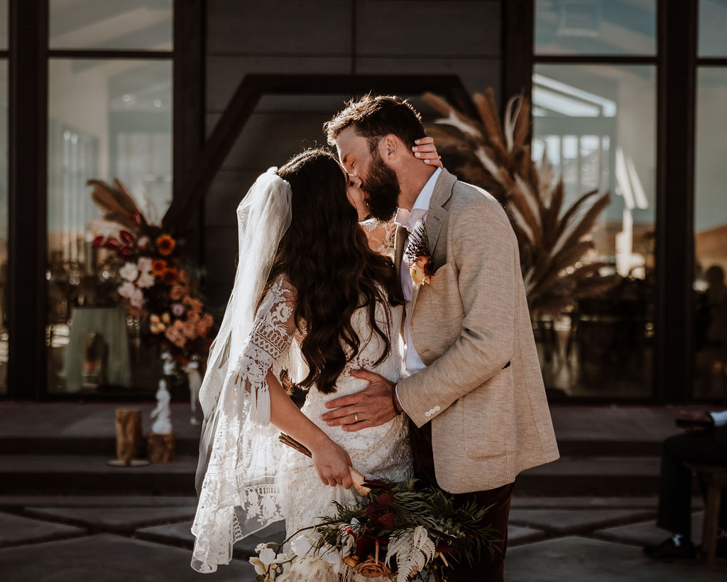 couple kisses at The Red Earth venue Moab wedding