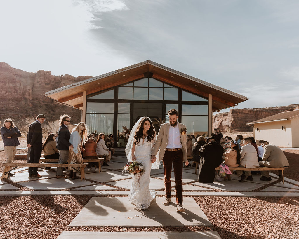 couple exits wedding ceremony at Red Earth Venue