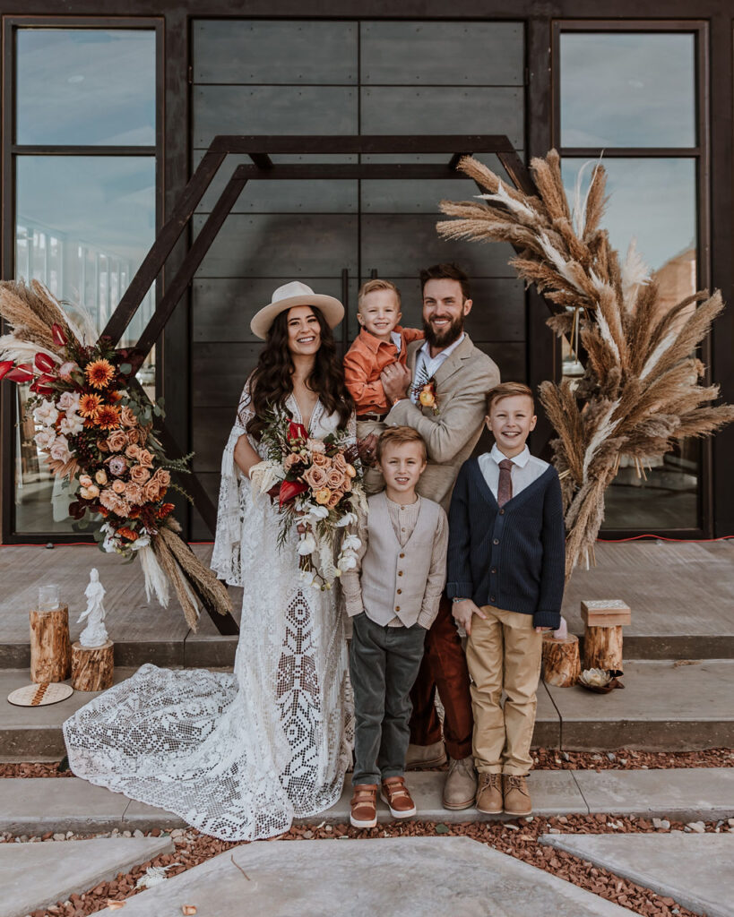 couple poses with family during The Red Earth Venue Moab wedding