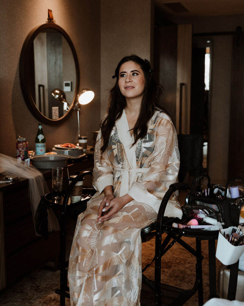 bride gets ready on wedding day in silk robe