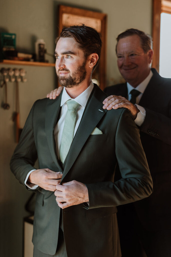 groom buttons up suit jacket