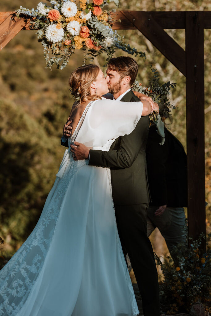 couple kisses at Whispering Oaks Ranch sunset ceremony